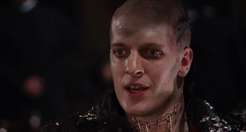 Movie still from “Highlander” (1986), directed by Russell Mulcahy – A person with a bald head; Close Up shot, Low angle