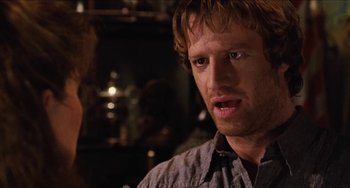 Movie still from “Highlander” (1986), directed by Russell Mulcahy – A person wearing a gray shirt; Close Up shot, Over the shoulder angle