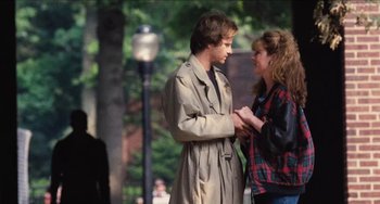 Movie still from “Highlander” (1986), directed by Russell Mulcahy – A man and a woman standing next to each other on the street; Medium shot, Over the shoulder angle