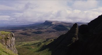 Movie still from “Highlander” (1986), directed by Russell Mulcahy – A view of a mountain range from a distance; Extreme Wide shot, High angle
