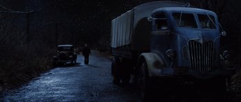 Movie still from “Hoffa” (1992), directed by Danny DeVito – A man walking down a street next to an old truck; Extreme Wide shot, Low angle