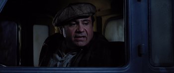 Movie still from “Hoffa” (1992), directed by Danny DeVito – A man with a hat and a jacket on looking out a window; Close Up shot, Low angle