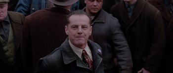 Movie still from “Hoffa” (1992), directed by Danny DeVito – A person wearing a suit and tie; Medium shot, Low angle