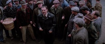 Movie still from “Hoffa” (1992), directed by Danny DeVito – A group of men standing next to each other on the street; Medium shot, High angle