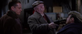 Movie still from “Hoffa” (1992), directed by Danny DeVito – An older man smoking a cigarette while holding a cell phone; Close Up shot, High angle