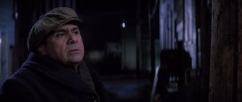 Movie still from “Hoffa” (1992), directed by Danny DeVito – A man wearing a hat sitting in a dark room at night; Close Up shot, Over the shoulder angle