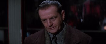 Movie still from “Hoffa” (1992), directed by Danny DeVito – A person wearing a suit and tie; Close Up shot, Over the shoulder angle