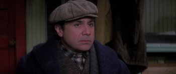 Movie still from “Hoffa” (1992), directed by Danny DeVito – A person wearing a hat and a tie; Close Up shot, High angle