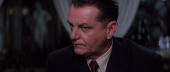 Movie still from “Hoffa” (1992), directed by Danny DeVito – An older man wearing a suit and a tie; Close Up shot, Low angle