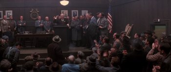 Movie still from “Hoffa” (1992), directed by Danny DeVito – A group of men standing in front of a podium; Wide shot, High angle