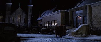 Movie still from “Hoffa” (1992), directed by Danny DeVito – A group of people walking on a snowy sidewalk; Extreme Wide shot, Low angle
