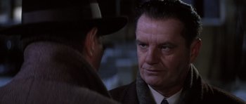 Movie still from “Hoffa” (1992), directed by Danny DeVito – A man in a suit and tie talking to another man; Close Up shot, Over the shoulder angle
