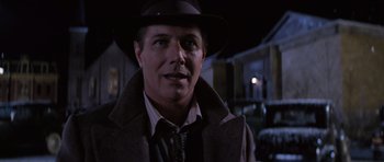 Movie still from “Hoffa” (1992), directed by Danny DeVito – A person wearing a hat and a coat; Close Up shot, Over the shoulder angle