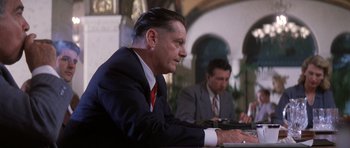 Movie still from “Hoffa” (1992), directed by Danny DeVito – A man in a suit and tie sitting in front of a computer; Medium shot, Low angle