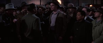 Movie still from “Hoffa” (1992), directed by Danny DeVito – A group of men standing next to each other; Medium shot, Over the shoulder angle