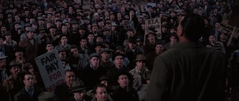 Movie still from “Hoffa” (1992), directed by Danny DeVito – A large group of men in a crowd of people wearing hats; Wide shot, High angle