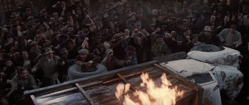 Movie still from “Hoffa” (1992), directed by Danny DeVito – A group of people standing around a fire; Wide shot, High angle