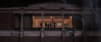 Movie still from “Hoffa” (1992), directed by Danny DeVito – A group of people standing on a balcony at night; Extreme Wide shot, Low angle