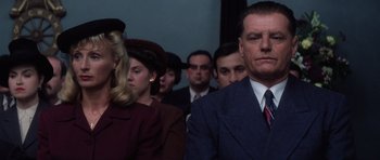 Movie still from “Hoffa” (1992), directed by Danny DeVito – A group of men and women sitting in a room together; Medium shot, Low angle