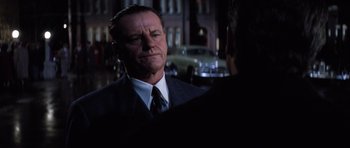 Movie still from “Hoffa” (1992), directed by Danny DeVito – A man in a business suit talking to someone; Close Up shot, Over the shoulder angle