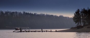 Movie still from “Hoffa” (1992), directed by Danny DeVito – A person walking on a pier near a body of water; Extreme Wide shot, Low angle
