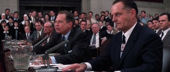 Movie still from “Hoffa” (1992), directed by Danny DeVito – A group of men sitting in front of microphones in a room; Close Up shot, Over the shoulder angle
