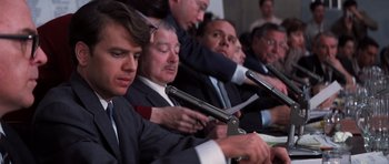 Movie still from “Hoffa” (1992), directed by Danny DeVito – A group of men sitting in a row holding guns; Close Up shot, Low angle