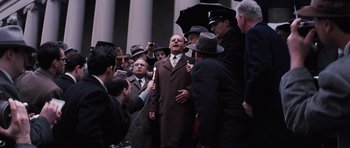 Movie still from “Hoffa” (1992), directed by Danny DeVito – A group of men standing next to each other on the street; Wide shot, Low angle