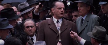 Movie still from “Hoffa” (1992), directed by Danny DeVito – A group of men standing next to each other holding microphones; Medium shot, Over the shoulder angle