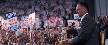 Movie still from “Hoffa” (1992), directed by Danny DeVito – A crowd of people holding up signs in front of a speaker; Medium shot, Low angle