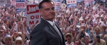 Movie still from “Hoffa” (1992), directed by Danny DeVito – A man standing in front of a group of people; Medium shot, Low angle