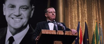 Movie still from “Hoffa” (1992), directed by Danny DeVito – A man standing at a podium with a microphone; Medium shot, Low angle