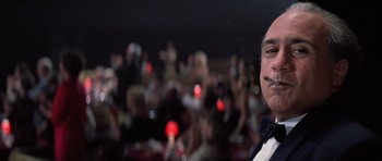 Movie still from “Hoffa” (1992), directed by Danny DeVito – A man in a crowd of people is smoking a cigarette; Close Up shot, Low angle