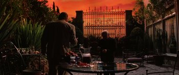 Movie still from “Hoffa” (1992), directed by Danny DeVito – Two people are sitting at a table outside; Wide shot, Low angle