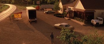 Movie still from “Hoffa” (1992), directed by Danny DeVito – A person walking down a street near a building; Extreme Wide shot, High angle