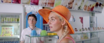 Movie still from “Holiday” (2018), directed by Isabella Eklöf – A woman wearing an orange straw hat; Close Up shot, Over the shoulder angle