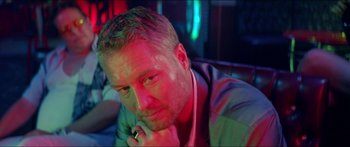 Movie still from “Holiday” (2018), directed by Isabella Eklöf – A person sitting at a table; Close Up shot, High angle