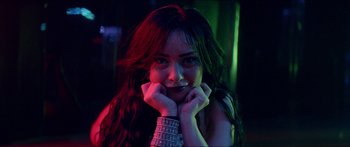 Movie still from “Holiday” (2018), directed by Isabella Eklöf – A beautiful woman posing for a picture in a dark room; Close Up shot, Low angle