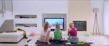 Movie still from “Holiday” (2018), directed by Isabella Eklöf – Three young children sitting on the floor watching television; Wide shot, High angle