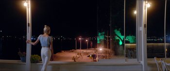 Movie still from “Holiday” (2018), directed by Isabella Eklöf – A woman standing on a beach at night; Wide shot, Low angle