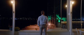 Movie still from “Holiday” (2018), directed by Isabella Eklöf – A man standing on the side of a road at night; Wide shot, Low angle