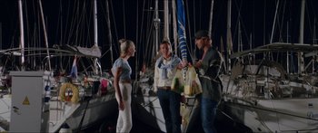 Movie still from “Holiday” (2018), directed by Isabella Eklöf – A group of people standing on top of a boat at night; Medium shot, Over the shoulder angle