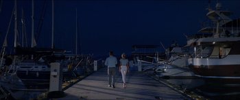 Movie still from “Holiday” (2018), directed by Isabella Eklöf – A man and a woman walking on a pier at night; Wide shot, Low angle