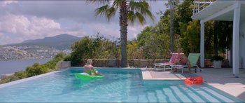 Movie still from “Holiday” (2018), directed by Isabella Eklöf – A woman is swimming in a pool on a float; Extreme Wide shot, High angle