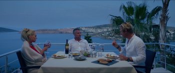 Movie still from “Holiday” (2018), directed by Isabella Eklöf – A group of people sitting at a table with food; Wide shot, Over the shoulder angle