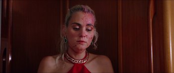 Movie still from “Holiday” (2018), directed by Isabella Eklöf – A woman with a red dress and a chain around her neck; Close Up shot, High angle
