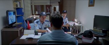 Movie still from “Holiday” (2018), directed by Isabella Eklöf – Two police officers sitting at a table in front of a mirror; Medium shot, Over the shoulder angle