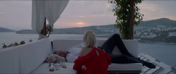 Movie still from “Holiday” (2018), directed by Isabella Eklöf – A man and a woman laying on a white couch; Medium shot, High angle