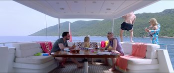 Movie still from “Holiday” (2018), directed by Isabella Eklöf – A group of people sitting at a table on top of a boat; Wide shot, High angle