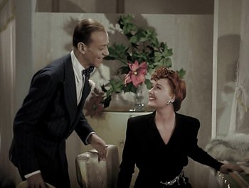 Movie still from “Holiday Inn” (1942), directed by Robert Allen – A man and a woman are laughing together in a room; Medium shot, High angle